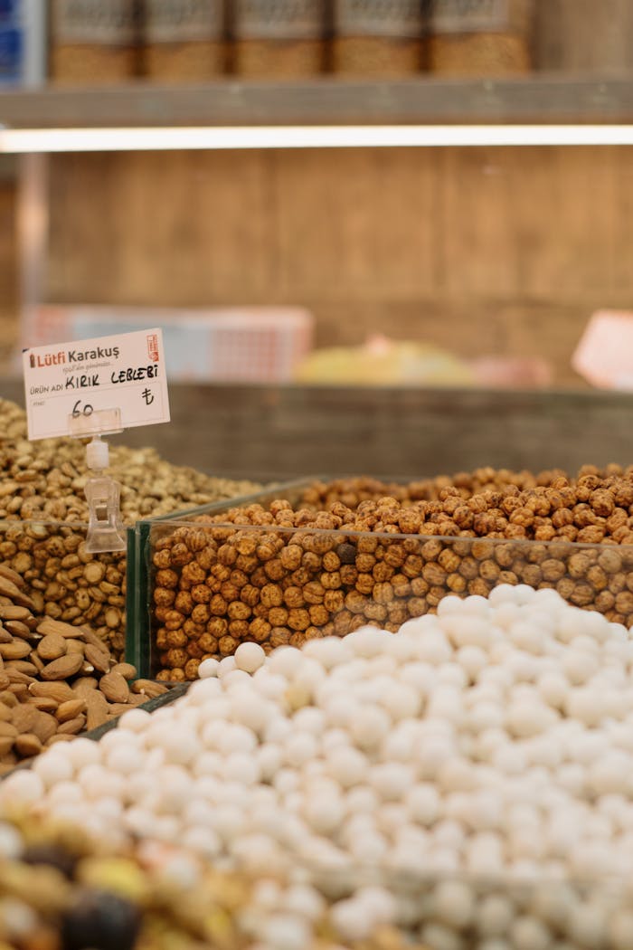 Close-up of various nuts and snacks at a Turkish market with a price sign.